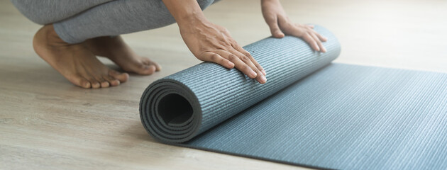 Hobby at home concept. woman rolling yoga mat off prepare to exercise in the morning
