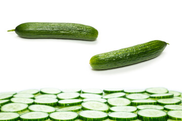 Fresh green slices of cucumber as background.