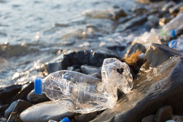 plastic pollution of Black sea. old crumpled bottle on coast. environmental protection
