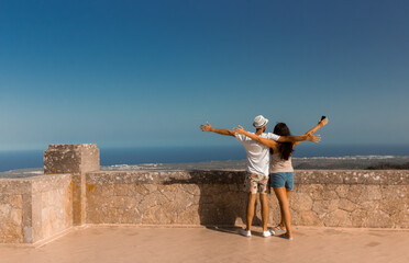 couple back to back open arms landscape