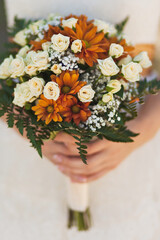 Bright wedding bouquet in hands of the bride