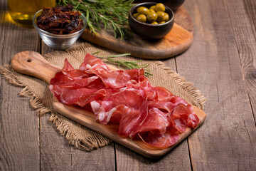 Italian slices of coppa, capocollo, capicollo or cured ham with rosemary. Raw food.  
