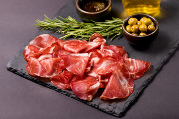 Italian slices of coppa, capocollo, capicollo or cured ham with rosemary. Raw food.   - obrazy, fototapety, plakaty