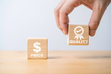 Hand holding quality icon to select between price and quality of product concept. - obrazy, fototapety, plakaty