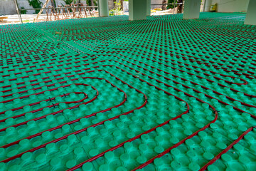 Underfloor heating pipes laid on green insulation material in the building under construction