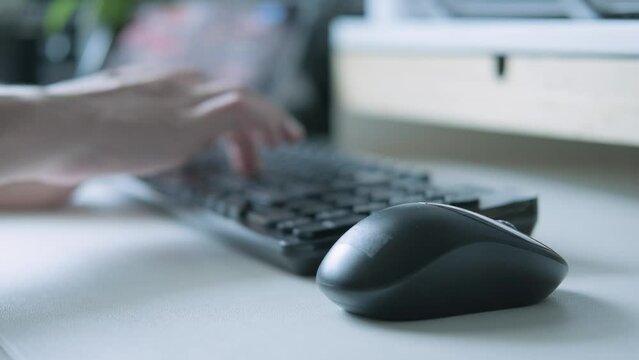 Close up of male's hand navigating computer program with mouse in him home office. Click black computer mouse on a work desk. Working with a PC or laptop. Close-up Footage of the workplace in 4K