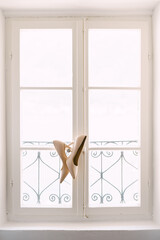 Bride's shoes on the window frame with metal bars.