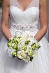 Bright wedding bouquet in hands of the bride