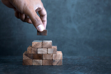 Hand place wooden block stacked concept of prevent collapse or crash of financial business and risk...