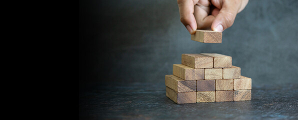 Hand place wooden block stacked concept of prevent collapse or crash of financial business and risk...