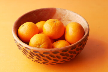 close up of slice of orange fruits in a bowl 