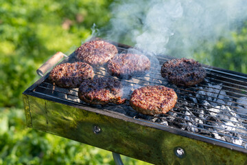 Close up of meat on grill at daylight, hamburgers