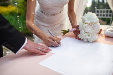 Obraz na płótnie Canvas The bride puts her signature at the wedding ceremony