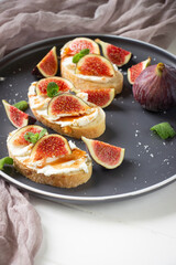 Healthy sandwiches with fresh figs and cream cheese, mint leaves, white  plate, white background, healthy eating, healthy sandviches