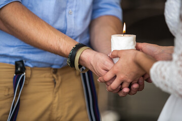 Candle in the hands of the bride and groom