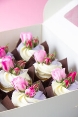 Cup cakes with pink  roses in box for delivery, pink background