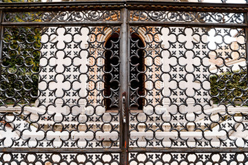 Forged gate with floral ornament in the shape of a four-leafed leaf. Close-up