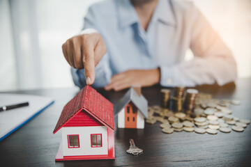 House model with stack coins, business hand is planning savings money of coins for buy home....