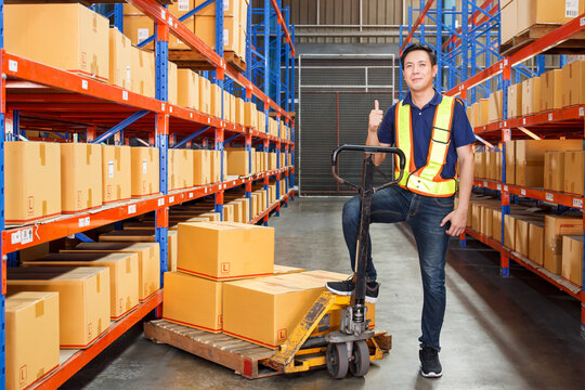 Happy Asian senior supervisor working - inspecting an items in the warehouse.