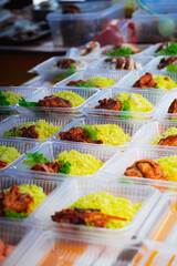 Typical Malaysian daily food at street stall or bazaar called Nasi Ayam Tomato packed in bio degradable plastic container .