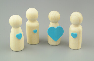 People with different love emotions concept. Female and male wooden people figures with different size hearts.	