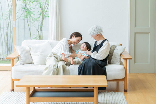 リビングにいる笑顔の親子（家族・ファミリー・育児・子育て・孫・おばあちゃん・帰省）