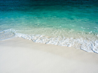 Scenic view of soft wave and white foam on white sand beach tropical island with crystal clear turquoise sea water. Sunrise Beach, Koh Lipe Island, Satun, Thailand. Minimal background.