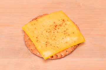 Crispy Cracker Sandwich with Cheese and Paprika on Wooden Cutting Board
