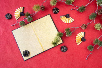 日本の正月イメージ　　金屏風と扇と水引と松の造花（赤バック）