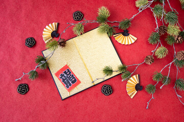 日本の正月イメージ　　金屏風と扇と水引と凧と松の造花（赤バック）