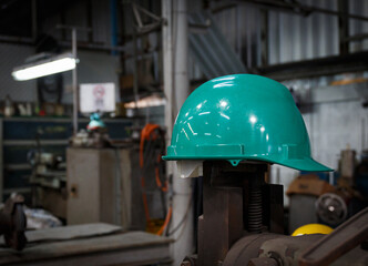 A green helmet is placed on top of the machine. in heavy industry