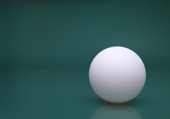 A white ball on a green background ...