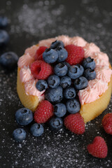 Cake with cream covered with juicy berries.
