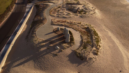 The Hand or La Mano sculpture on beach at sunrise and cityscape in background, Punta del Este in Uruguay. Top down view
