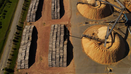 Aerial top-down shot over piles of trunks and sawdust mountains in paper mill factory. Fray Bentos in Uruguay © Santiago