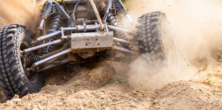 Off road vehicle motion the wheels tires off road dust cloud in desert, Offroad vehicle bashing through sand in the desert, off oad racing.