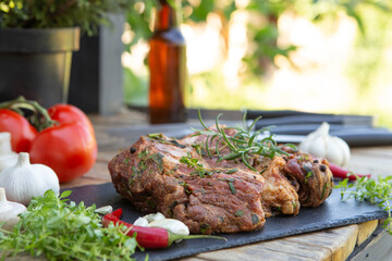 Marinated beef steak on wooden table top. Healthy food concept. Beef cut and spices for cooking bbq sauce outdoors, garden kitchen