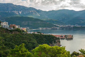 Fototapeta na wymiar Landscape aerial view of bay of the old historical city Budva, mountains and forests of Montenegro, on background of dramatic sky