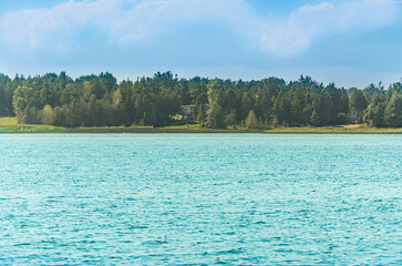 Cottages by Lake Huron shoreline in Pike Bay, surrounded by forest at summer day. Cottages for seasonal vacation rent and personal leisure.