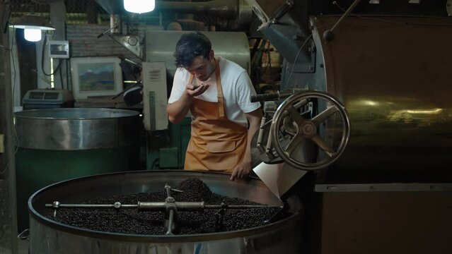 coffee roaster is taking out the roasted coffee beans to see if they are ready to come out of the roaster.
