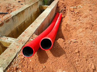 SELANGOR, MALAYSIA -AUGUST 2, 2021: Heavy-duty underground pipes lay in the ground at a construction site. this pipe will be the path to the high voltage electric cable.