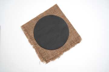 Fototapeta na wymiar round empty black stone plate on sack white