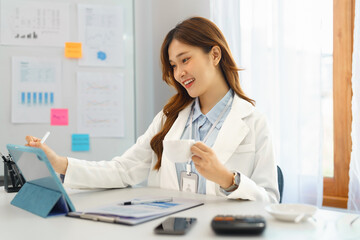 Successful business concept, Businesswoman drinking coffee and taking notes data on tablet