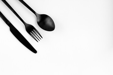 Black fork, spoon, knife isolated on white.