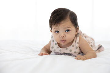 Fototapeta premium cute baby crawling on bed and drooling from mouth
