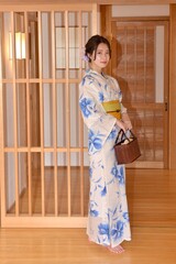 日本家屋の廊下でポーズをとる浴衣を着た若く美しい女性