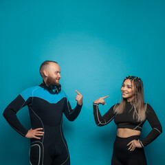Cute friends in sportswear smiling while standing together on blue background