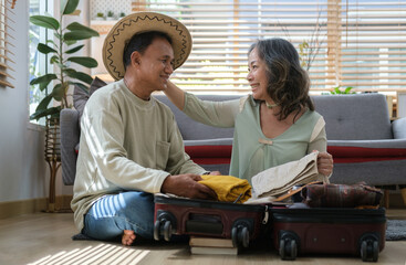 Romantic retired couple packing clothes into travel bag, preparing for the trip. Activity after retirement, family vacation concept.