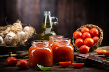 Fresh Tomato sauce and juice . On a wooden background.