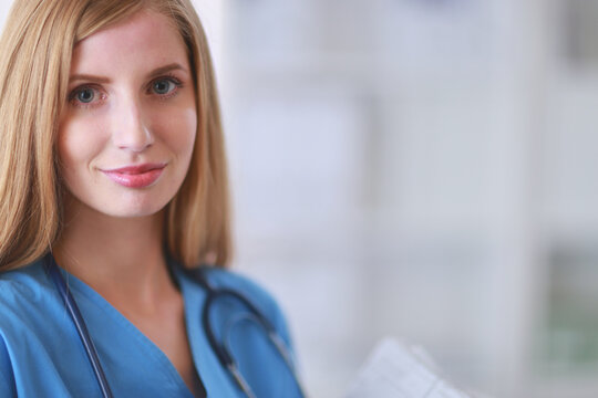 A female doctor with a folder, standing isolated on white background